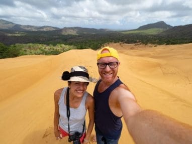 Un homme et une femme prenant un selfie sur une dune de sable.